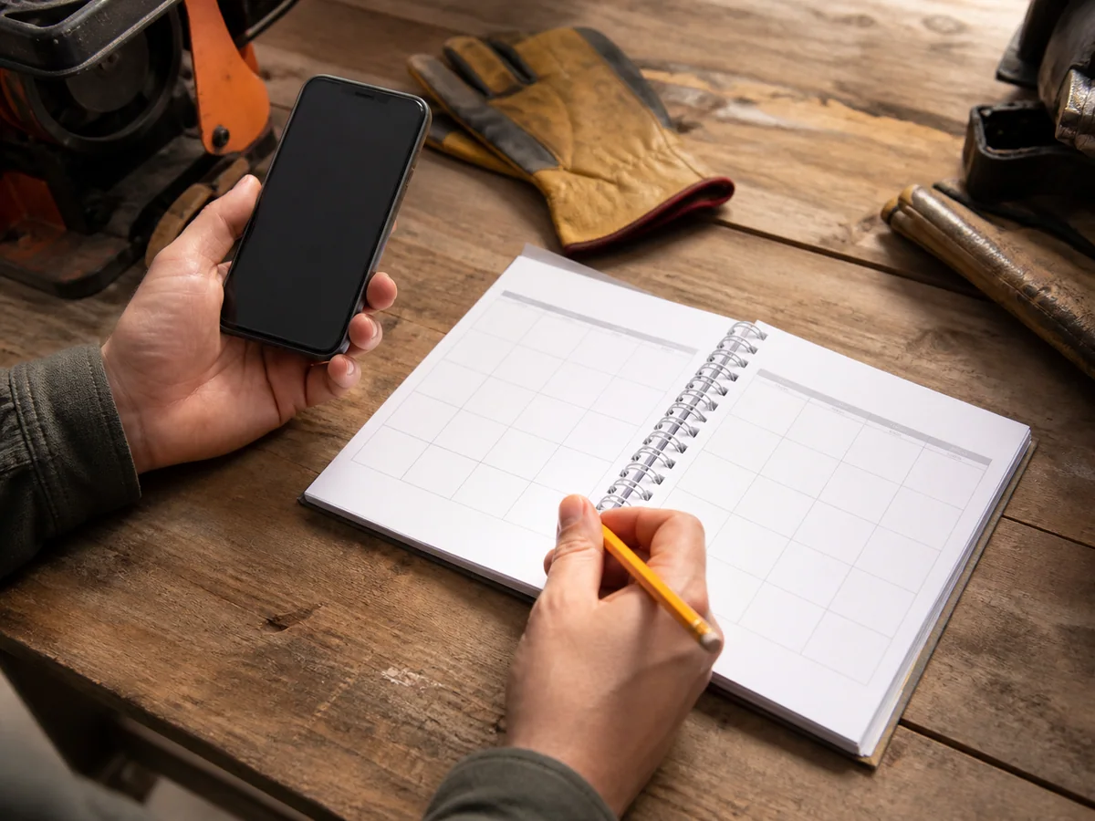 Planificación de fechas con agenda y teléfono en una mesa de trabajo